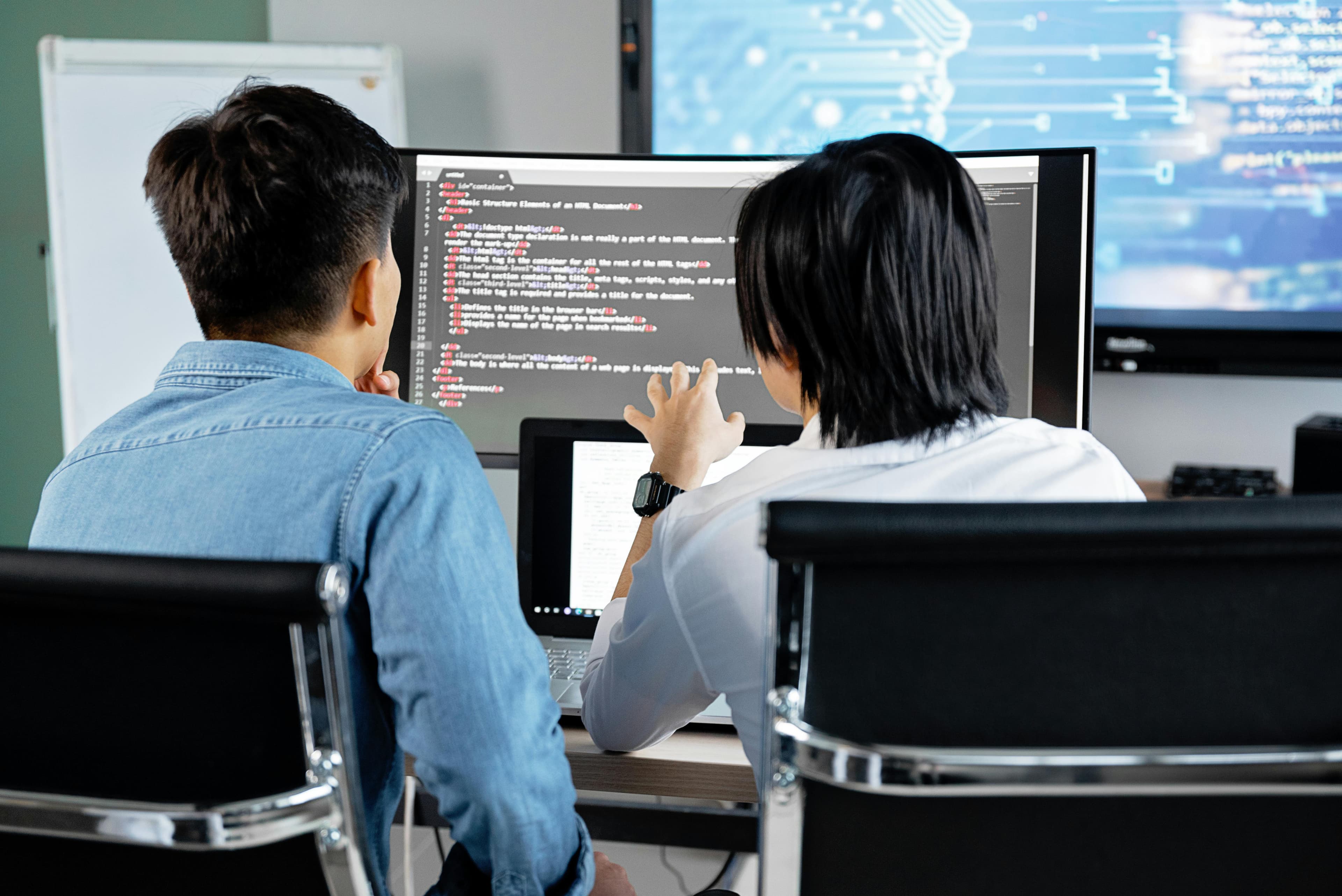 Zwei Personen arbeiten gemeinsam am Computer in einer hellen Lernumgebung